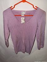 Front view of pink Tracy M sweater on hanger
