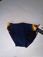 Front view of navy and gold TYR swim brief