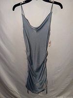 Full view of baby blue spaghetti-strap ruched mini dress on hanger
