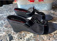 Side view of both shoes showing patent strap, chain detail and wedge heel profile