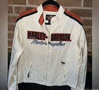 Front view of cream Harley-Davidson women’s jacket with logo and zip pockets