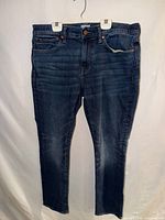 Full front view of the jeans hanging to show overall style, wash and straight leg cut