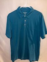 Front view of blue polo shirt on hanger