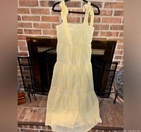 Full front view of yellow and white striped seersucker maxi dress hanging