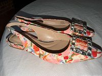 Side view of both floral slingback flats showing upper, buckle and heel