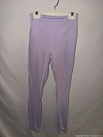 Full view of pale purple leggings hanging on hanger