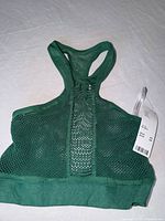 Front view of green mesh crop top with tag visible