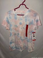 Front of pastel tie-dye Danskin T-shirt on hanger, tags visible