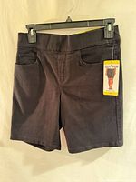 Front view of black DKNY shorts with tag attached