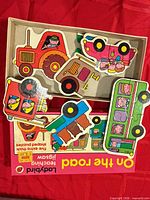 Open box showing five shaped vehicle puzzles