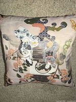 Front of pillow showing Japanese style artwork and floral motifs