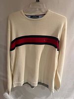 Front view of cream sweater with red/navy stripe