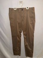Full view of khaki pants front on hanger