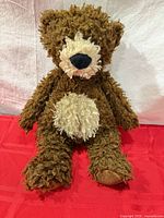 Full view of seated brown shaggy teddy bear showing overall appearance and size