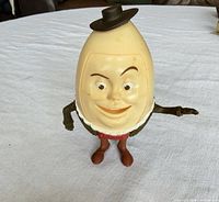 Front view showing face, hat, arms, red legs, brown boots