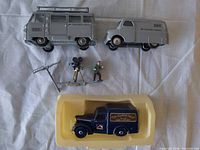 Overview of three die-cast vans, camera setup, boom stand and figure