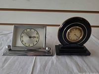 Both desk clocks front view showing cases, dials and bases