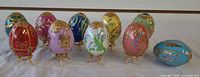 Group shot of ten enamel eggs and nine stands