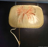 Front view of cream glass Art Deco wall sconce with pink floral motif and pull chain