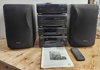 Front view of full Technics system stack with both speakers, manual and remote