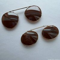 Both clip-on shades side by side showing size difference and brown lenses