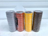 four stacks of sealed rolls in gray, orange, yellow, brown