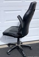 Left side view of black gaming office chair showing profile, armrest, base and upholstery