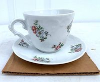Tea cup on saucer showing floral pattern and handle style