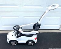 Right side view of white Mercedes push ride-on car with handle attached
