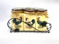 Front view of three rooster candle holders in metal rack