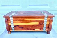 Front view of cedar chest showing metal straps and wood grain