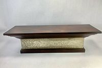 front view of shelf showing wood top and decorative metal band