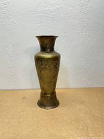 Full view of etched brass vase standing on surface