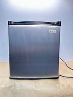 Front view of Magic Chef mini fridge showing stainless steel door and brand badge