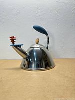 Full side view of kettle showing overall shape, handle, spout and whistle