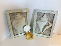 Two framed shell relief plaques and shell trinket box displayed together