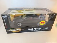 Front and side view of boxed 1:18 black Pontiac GTO model