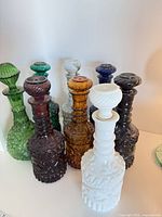 Group shot of all eight decanters showing colours and stoppers