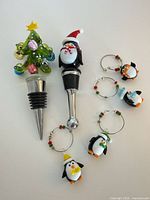 Full set: two stoppers and four penguin charms displayed on white background