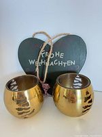 Front view of gold tealight holders with wooden heart sign