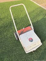 Full view of Retriever push lawn sweeper showing handle, wheels, housing