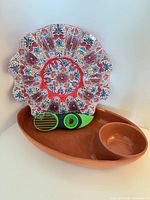 All three items: terracotta platter, floral plate, avocado slicer