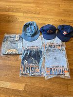 Overview of five packaged World Champion T-shirts and three hats