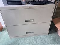 Front view of beige metal 2-drawer lateral file cabinet with printer on top