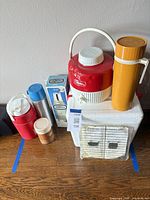 Group shot showing cooler, Coleman jug, thermoses, grill package