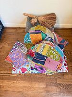 Group view of two patchwork cushions, accent rug, straw broom, wicker basket