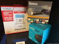 Three boxed electronics: ZoneGuard radio, Roku Streaming Stick+, Echo Dot