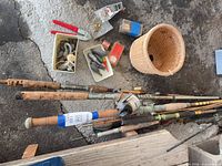 Group of fishing rods, wicker basket, tackle spread