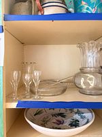 Shelf view showing pitcher, serving bowl with ladle, cordial glasses, bud vase, ceramic bowl