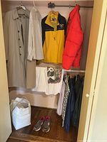 Overall view of closet showing trench coat, windbreaker, puffer, shorts, shirts, sneakers